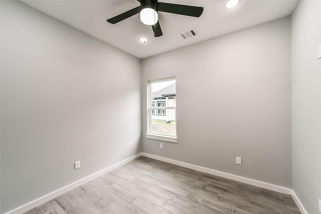 spare room with a ceiling fan, wood finished floors, baseboards, and visible vents