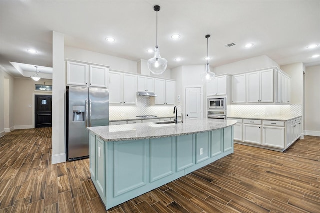 31021 Harvest Meadow Ln, Spring, TX 77386 - kitchen featuring appliances with stainless steel finishes, white cabinets, backsplash, dark wood finished floors, and recessed lighting