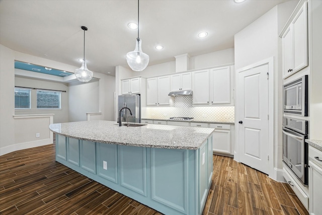 31021 Harvest Meadow Ln, Spring, TX 77386 - kitchen featuring stainless steel appliances, under cabinet range hood, white cabinets, and recessed lighting