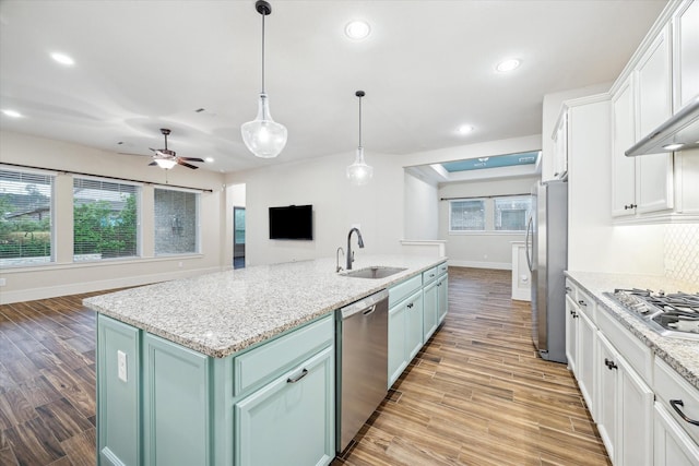31021 Harvest Meadow Ln, Spring, TX 77386 - kitchen featuring appliances with stainless steel finishes, blue cabinets, recessed lighting, white cabinetry, and light wood-type flooring