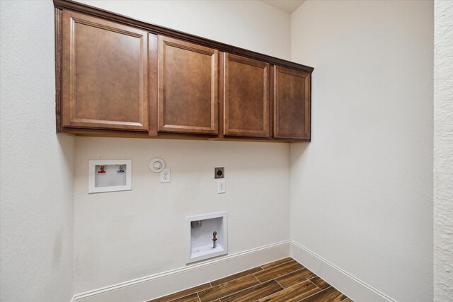 31021 Harvest Meadow Ln, Spring, TX 77386 - laundry room with hookup for an electric dryer, gas dryer hookup, washer hookup, cabinet space, and dark wood-type flooring