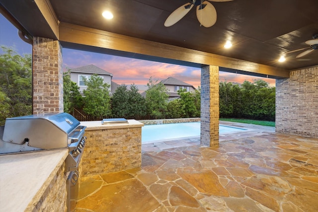 31021 Harvest Meadow Ln, Spring, TX 77386 - patio terrace at dusk featuring ceiling fan, an outdoor kitchen, a patio, and an outdoor pool