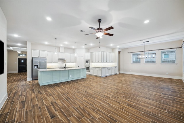 31021 Harvest Meadow Ln, Spring, TX 77386 - kitchen featuring stainless steel appliances, open floor plan, a ceiling fan, white cabinets, and recessed lighting