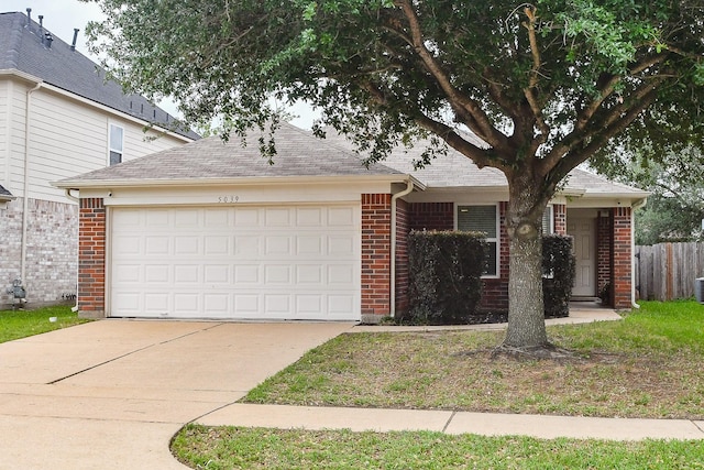 view of front of home with fence, roof with shingles, an attached garage, brick siding, and concrete driveway