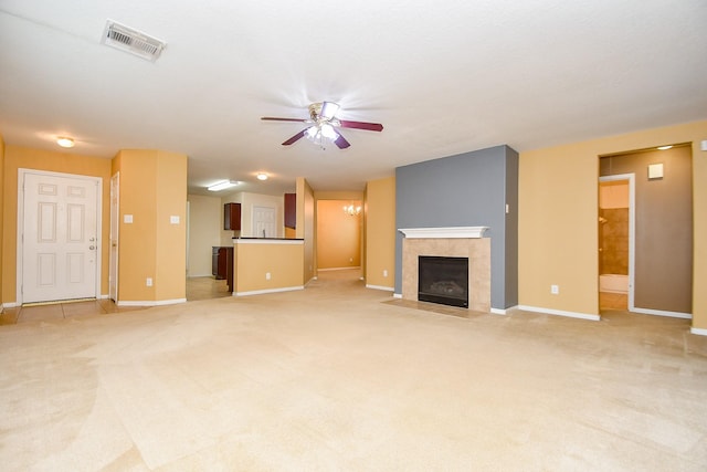 unfurnished living room with ceiling fan, light colored carpet, baseboards, a tile fireplace, and visible vents