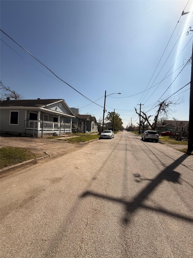 view of road featuring street lighting and curbs