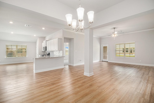 4411 Karam Lndg, Dickinson, TX 77539 - unfurnished living room with baseboards, light wood finished floors, ceiling fan with notable chandelier, and a healthy amount of sunlight