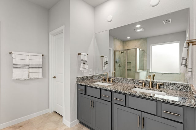 bathroom featuring a shower stall, baseboards, visible vents, and a sink