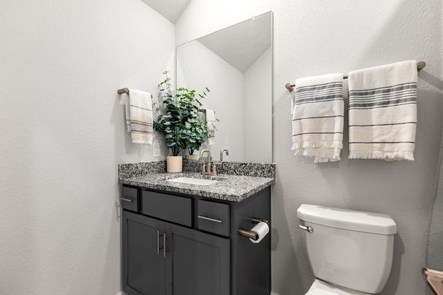 half bathroom with toilet and vanity