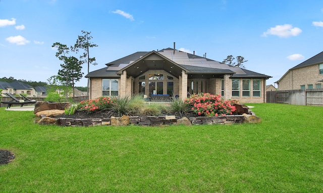 1002 Timberland Bay Ct, Pinehurst, TX 77362 - back of property featuring a yard, roof mounted solar panels, fence, and brick siding