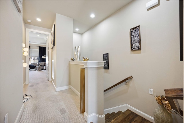hallway featuring baseboards, carpet floors, an upstairs landing, and recessed lighting