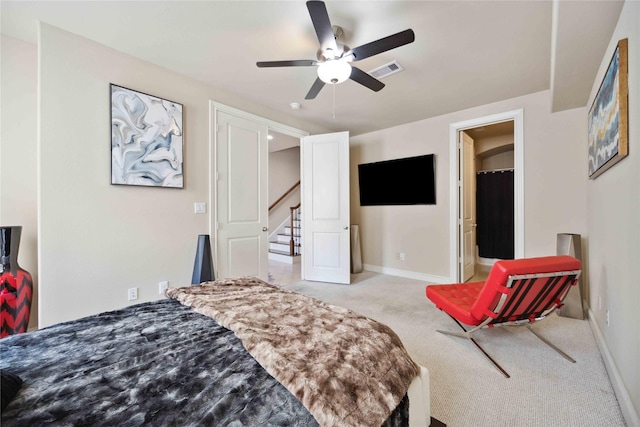carpeted bedroom featuring a walk in closet, baseboards, ceiling fan, and visible vents