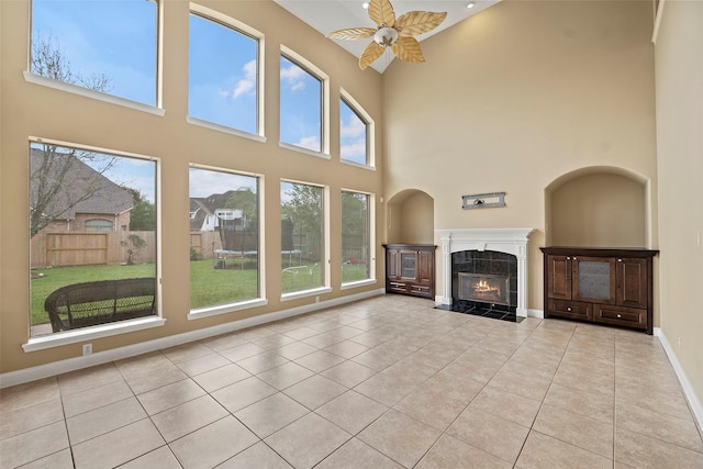 11812 Sea Shadow Bnd, Pearland, TX 77584 - unfurnished living room featuring tile patterned floors, a high ceiling, ceiling fan, and a high end fireplace