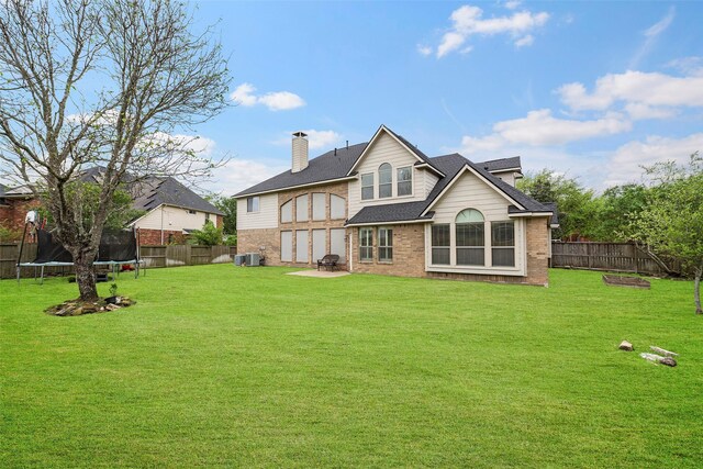 11812 Sea Shadow Bnd, Pearland, TX 77584 - rear view of property with a trampoline, a fenced backyard, brick siding, and a shingled roof