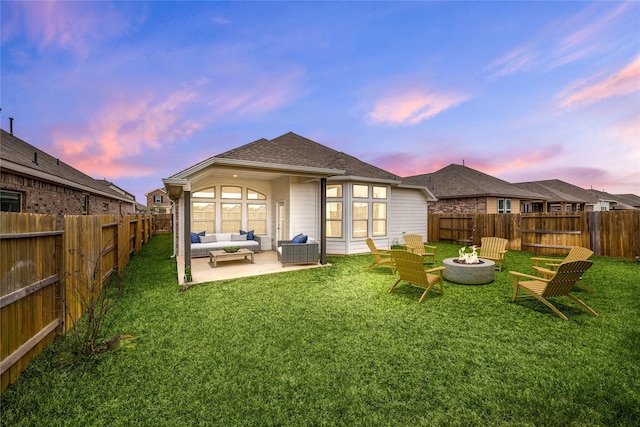 149 Sunray Creek Dr, Katy, TX 77493 - back of property at dusk with a fenced backyard, a yard, and an outdoor living space with a fire pit