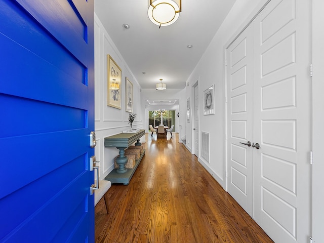 hallway with visible vents and wood finished floors