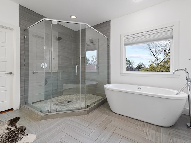 full bathroom with recessed lighting, a soaking tub, and a stall shower