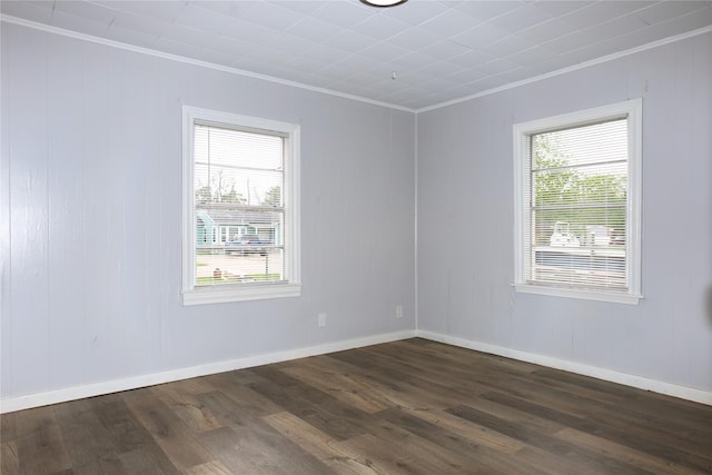 unfurnished room featuring dark wood finished floors, baseboards, and ornamental molding