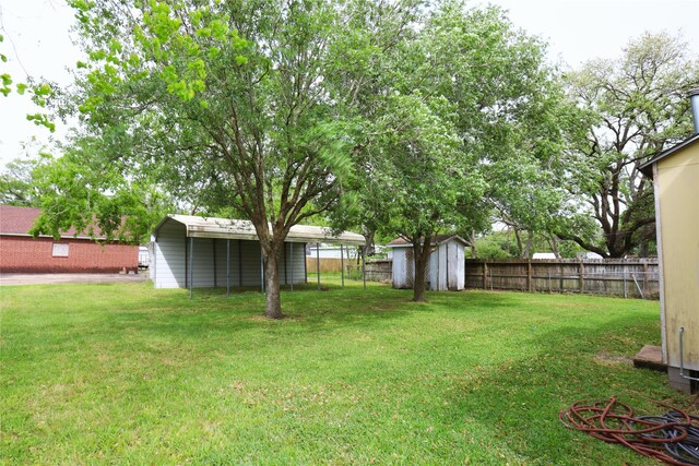 617 Hurst St, Angleton, TX 77515 - view of yard with fence, a storage shed, a detached carport, and an outbuilding