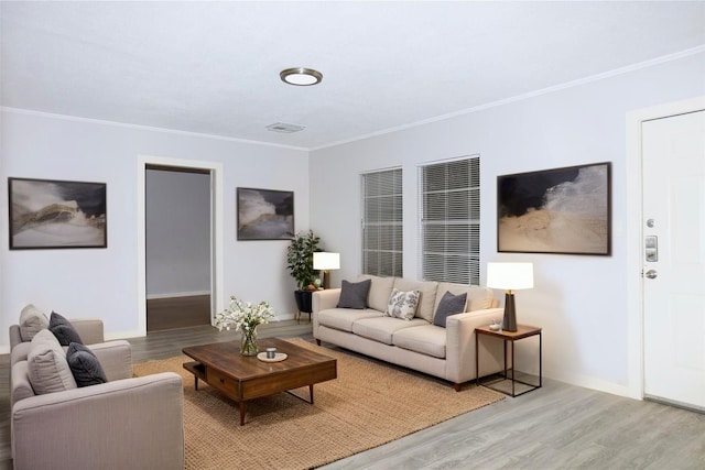 living room with crown molding, light wood-style flooring, and baseboards