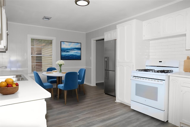 kitchen featuring light wood-style floors, stainless steel fridge, white gas stove, visible vents, and light countertops