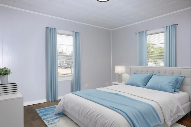 bedroom with ornamental molding, multiple windows, and wood finished floors