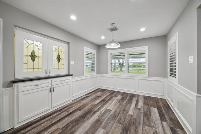 1613 Willow View St, La Porte, TX 77571 - unfurnished dining area featuring dark wood finished floors, recessed lighting, a wainscoted wall, and a decorative wall