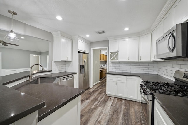 1613 Willow View St, La Porte, TX 77571 - kitchen featuring stainless steel appliances, a sink, white cabinetry, dark wood finished floors, and recessed lighting