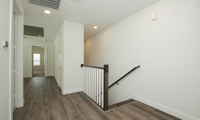corridor featuring an upstairs landing, visible vents, dark wood-style flooring, and baseboards
