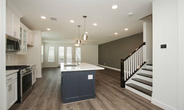 kitchen with ceiling fan, dark wood-type flooring, white cabinets, appliances with stainless steel finishes, and a sink