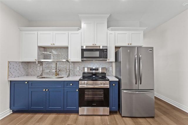 3513 Ursuline St, Galveston, TX 77550 - kitchen featuring blue cabinets, a sink, light countertops, and appliances with stainless steel finishes
