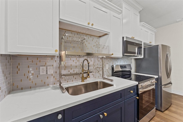 3513 Ursuline St, Galveston, TX 77550 - kitchen with white cabinetry, tasteful backsplash, appliances with stainless steel finishes, and blue cabinetry