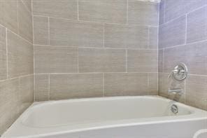 6657 Stearns St, Houston, TX 77021 - full bathroom featuring walk in shower and a washtub