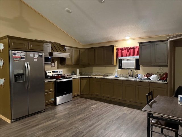 kitchen featuring lofted ceiling, wood finished floors, a sink, and appliances with stainless steel finishes