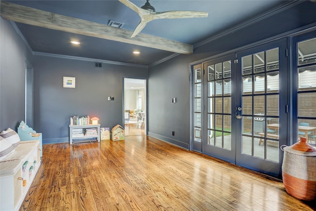 interior space featuring visible vents, crown molding, beam ceiling, wood finished floors, and baseboards