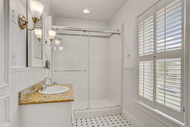 full bathroom featuring crown molding, a shower stall, tile patterned flooring, and vanity