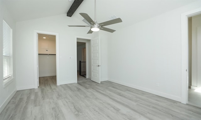 119 E 43rd St Unit A, Houston, TX 77018 - unfurnished bedroom with baseboards, a walk in closet, light wood-style floors, visible vents, and vaulted ceiling with beams