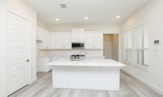 119 E 43rd St Unit A, Houston, TX 77018 - kitchen featuring a kitchen island with sink, stainless steel microwave, light countertops, and visible vents