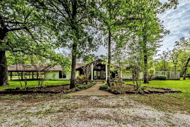 view of front of house with a front lawn, fence, and stucco siding
