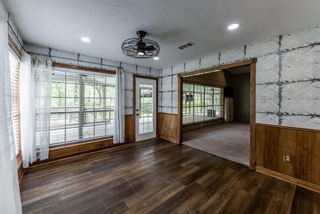 spare room featuring wallpapered walls, a wainscoted wall, and ceiling fan