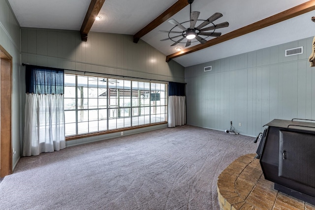 interior space featuring ceiling fan, lofted ceiling with beams, carpet, and visible vents
