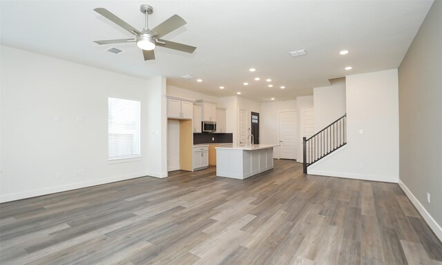 121 E 43rd St Unit B, Houston, TX 77018 - unfurnished living room featuring visible vents, recessed lighting, stairway, wood finished floors, and baseboards