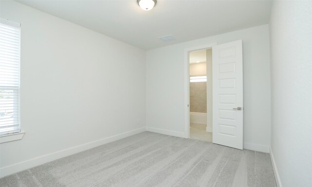 121 E 43rd St Unit B, Houston, TX 77018 - unfurnished bedroom with baseboards and light colored carpet