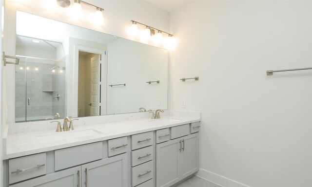 121 E 43rd St Unit B, Houston, TX 77018 - bathroom featuring a shower with shower door, double vanity, a sink, and baseboards