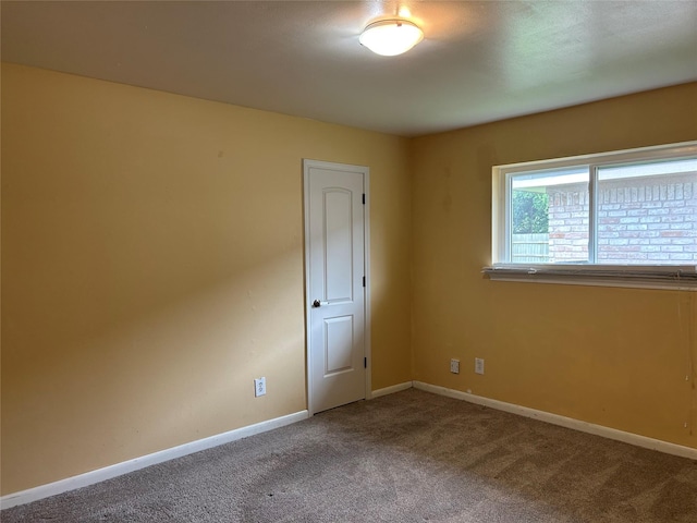 spare room featuring carpet and baseboards