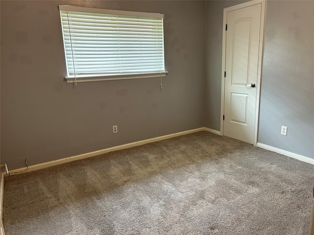 carpeted spare room with baseboards