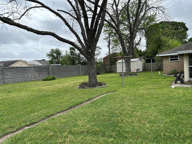 view of yard featuring a storage unit, an outbuilding, and a fenced backyard