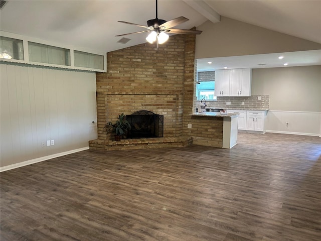 6018 Rena St, Houston, TX 77092 - unfurnished living room with ceiling fan, dark wood-style flooring, beamed ceiling, a fireplace, and high vaulted ceiling