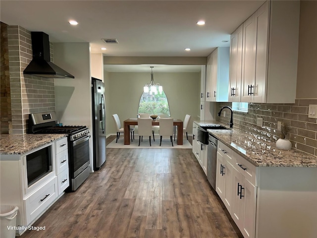 6018 Rena St, Houston, TX 77092 - kitchen featuring wall chimney range hood, stainless steel appliances, white cabinetry, decorative backsplash, and recessed lighting