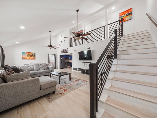 8007 Beluche Dr, Galveston, TX 77551 - living room with high vaulted ceiling, light wood-style flooring, recessed lighting, stairway, and a ceiling fan
